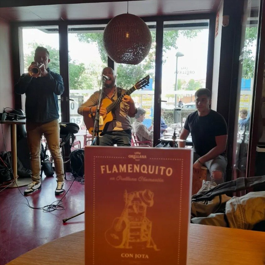 Grupo de música actuando en directo en un evento en Madrid, con público bailando y disfrutando de versiones flamenco-pop.